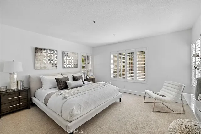 a bedroom with a bed a couch and a window