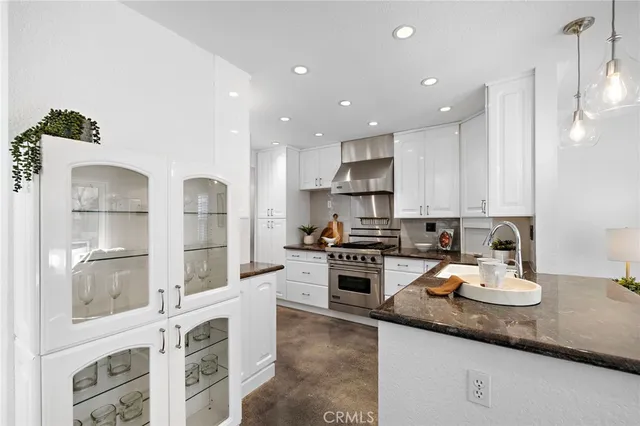 a kitchen with white cabinets and appliances