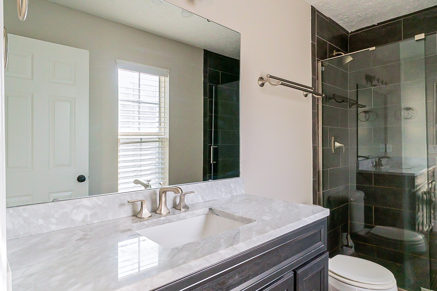 1604 Comanche Run Madison, TN 37115 - Photo 23 of 32 a bathroom with a granite countertop sink toilet a mirror and shower