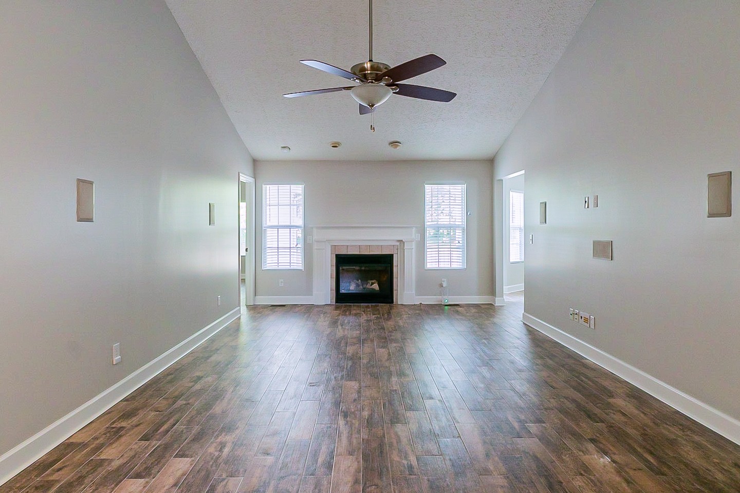 1604 Comanche Run Madison, TN 37115 - Photo 5 of 32 an empty room with wooden floor a ceiling fan a fireplace and windows