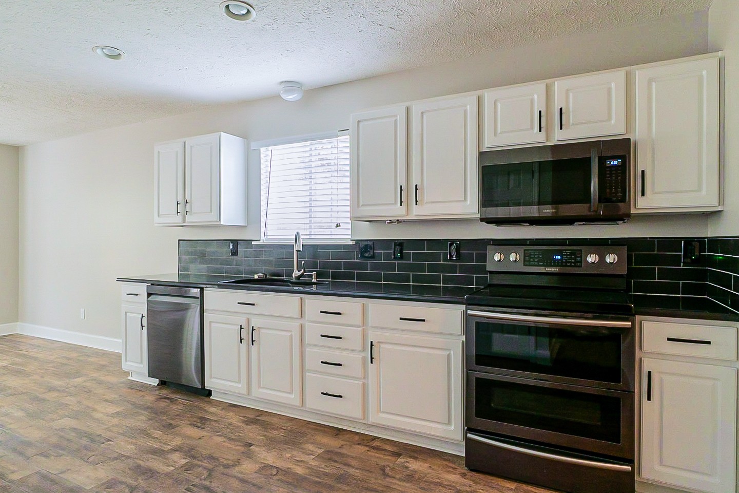 1604 Comanche Run Madison, TN 37115 - Photo 9 of 32 a kitchen with granite countertop white cabinets and stainless steel appliances