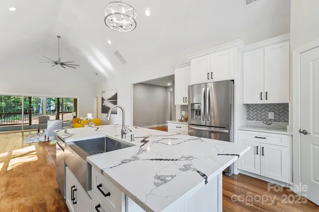 a kitchen with stainless steel appliances granite countertop a sink a stove and a refrigerator