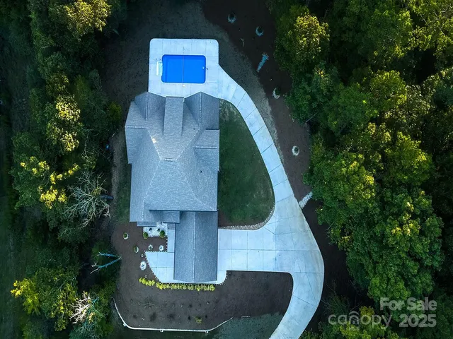 an aerial view of a house with a yard and trees