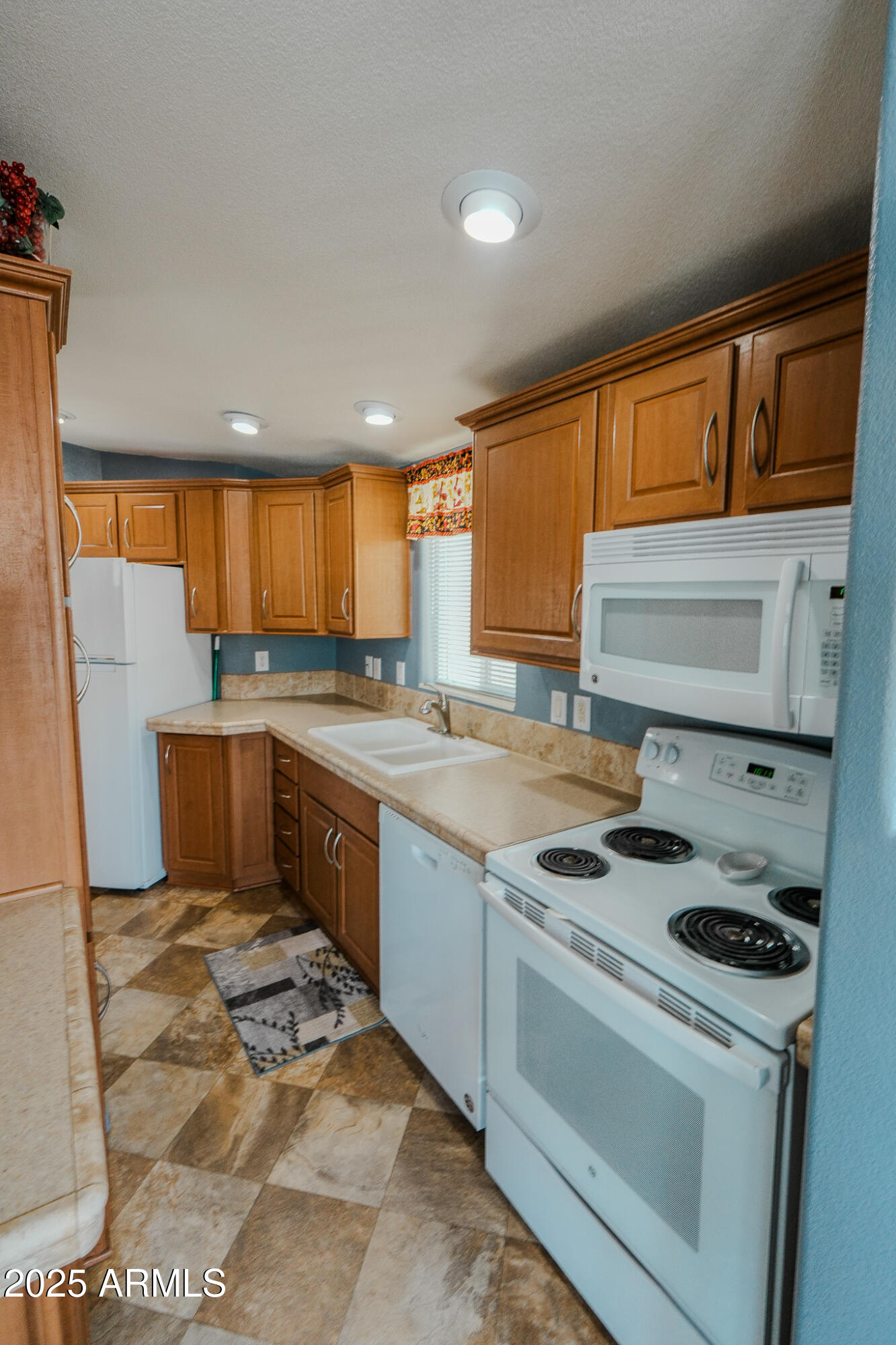 17200 West Bell Road, Unit 915 Surprise, AZ 85374 - Photo 24 of 32 a kitchen with stainless steel appliances granite countertop a stove a sink dishwasher and a refrigerator