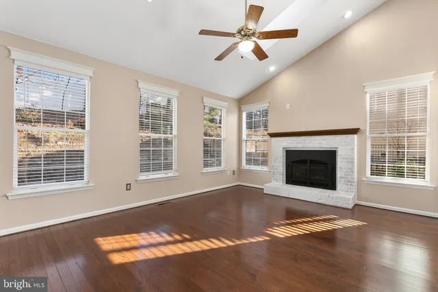 a view of empty room with wooden floor and fireplace
