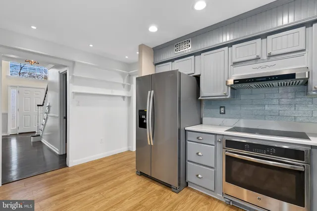 a kitchen with stainless steel appliances granite countertop a stove a sink and a refrigerator