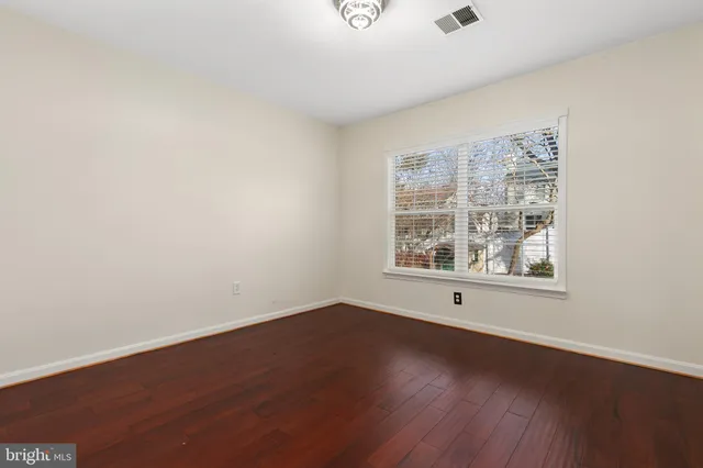 a spacious bathroom with a granite countertop sink a toilet and a mirror