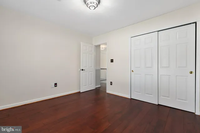 a view of a hallway with wooden floor and closet