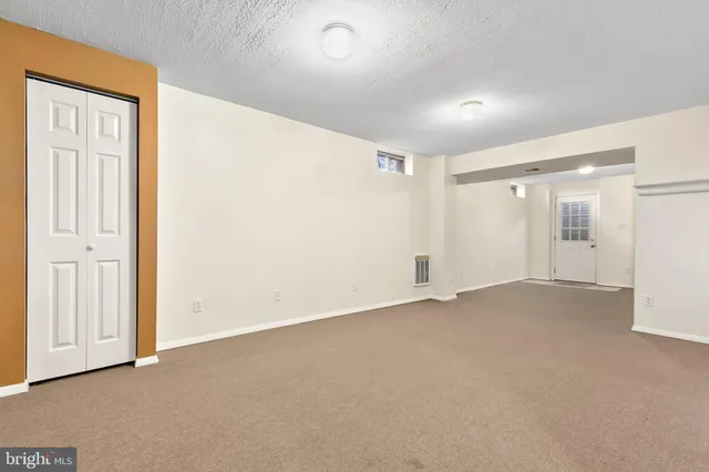 a view of a house with a yard and a wooden bench