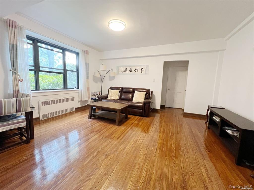 112-19 34th Avenue, Unit F Queens, NY 11368 - Photo 2 of 11 a living room with furniture and a wooden floor