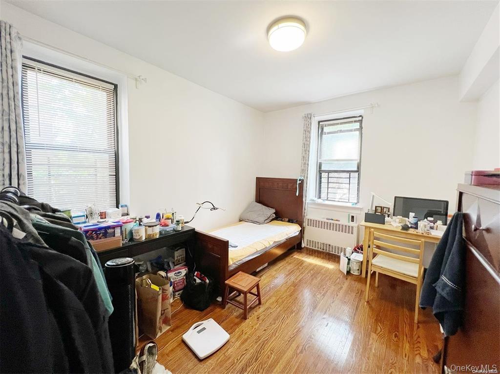 112-19 34th Avenue, Unit F Queens, NY 11368 - Photo 5 of 11 a bedroom with a bed and wooden floor