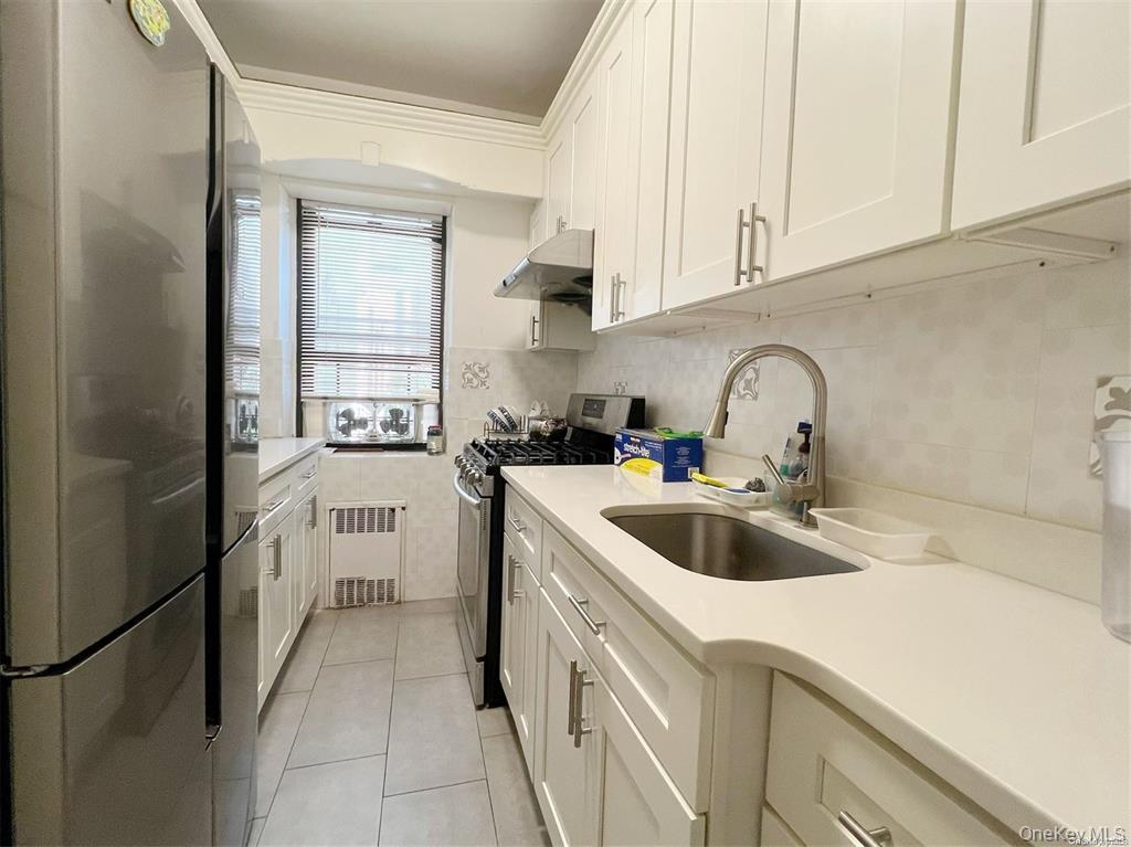 112-19 34th Avenue, Unit F Queens, NY 11368 - Photo 7 of 11 a kitchen with a sink and cabinets