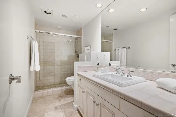 a spacious bathroom with a shower sink and toilet