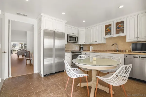 a kitchen with stainless steel appliances granite countertop a sink and a refrigerator