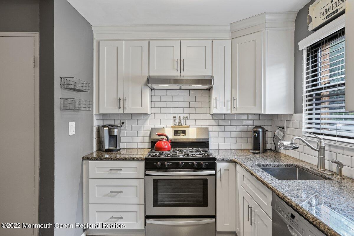 321 Spring Street, Unit 11 Red Bank, NJ 07701 - Photo 11 of 29 a kitchen with granite countertop white cabinets and stainless steel appliances