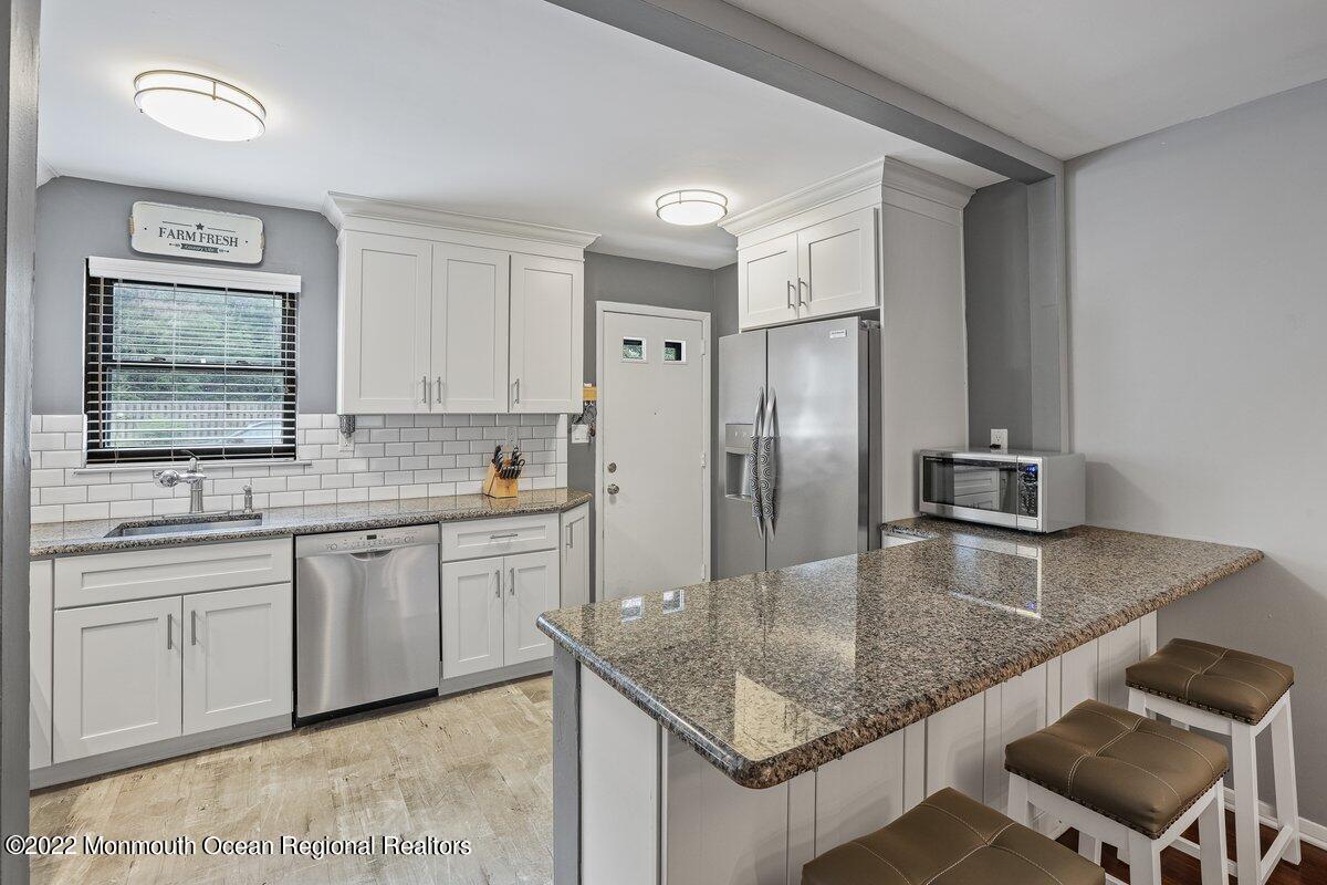 321 Spring Street, Unit 11 Red Bank, NJ 07701 - Photo 7 of 29 a kitchen with stainless steel appliances granite countertop a sink refrigerator and cabinets
