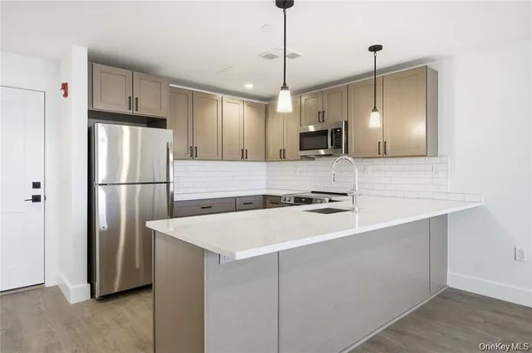 a kitchen with kitchen island a sink stainless steel appliances and cabinets