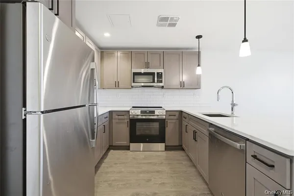 a kitchen with stainless steel appliances granite countertop a refrigerator sink and stove