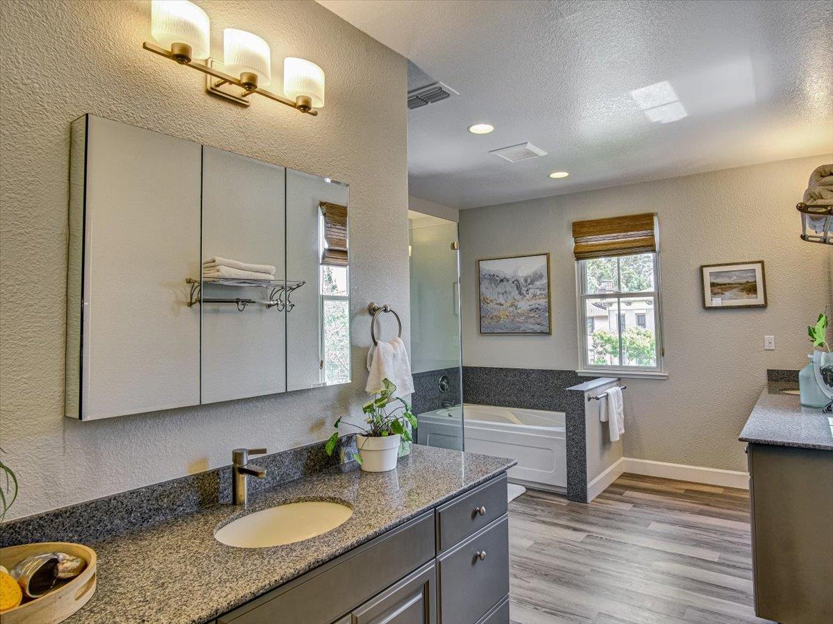 1042 Promenade Street Hercules, CA 94547 - Photo 18 of 60 a bathroom with double vanity sinks a mirror and a shower