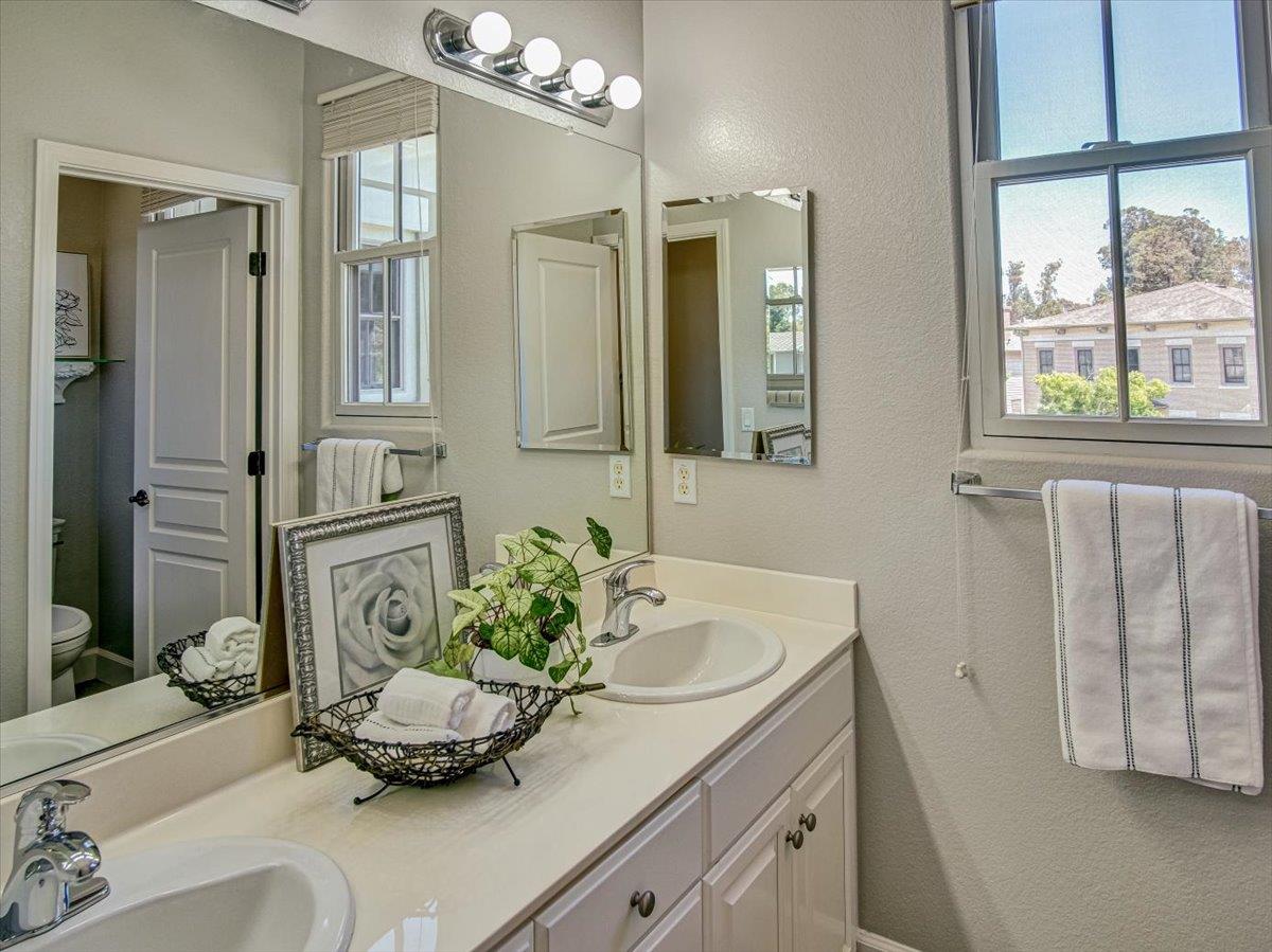1042 Promenade Street Hercules, CA 94547 - Photo 23 of 60 a bathroom with a granite countertop sink a large mirror and a shower