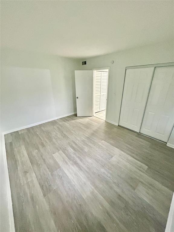 2252 Northwest 183rd Street, Unit 4 Miami Gardens, FL 33056 - Photo 9 of 15 a view of an empty room with wooden floor