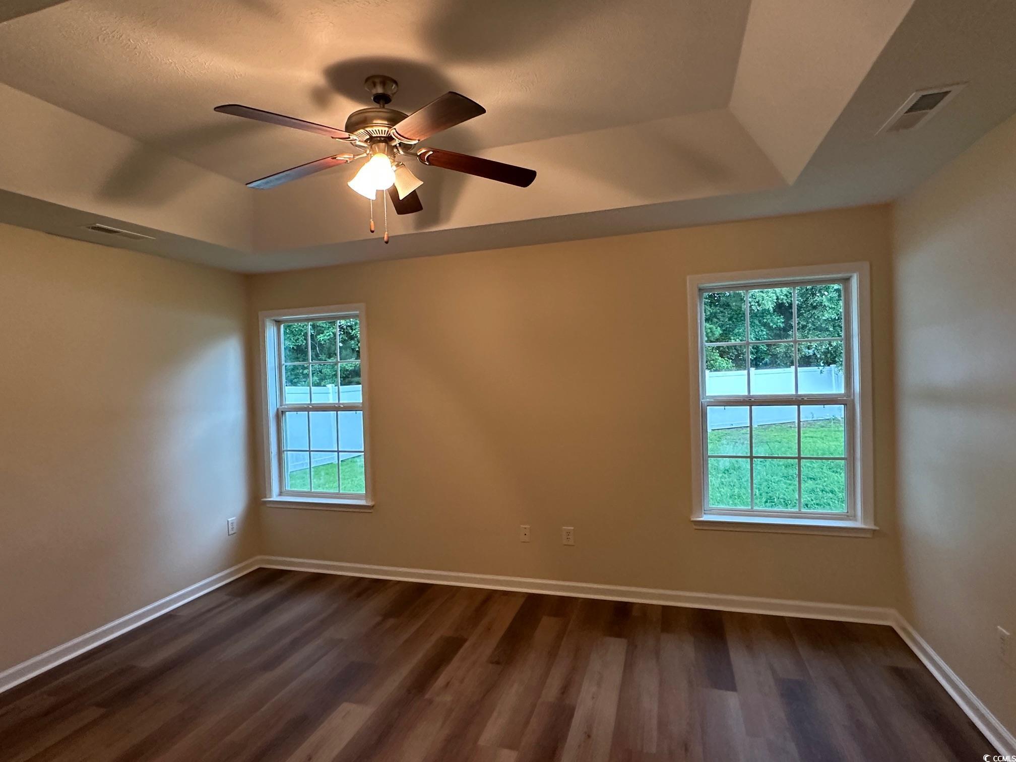 753 Bucklin Loop Myrtle Beach, SC 29579 - Photo 6 of 21 Empty room featuring a tray ceiling, dark wood-typ