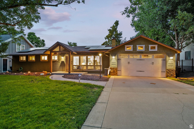 1709 Meadowmoor Road Holladay, UT 84117 - Photo 1 of 32 Exterior features a covered entry, multiple window styles, an attached garage with carriage-style doors, and solar panels