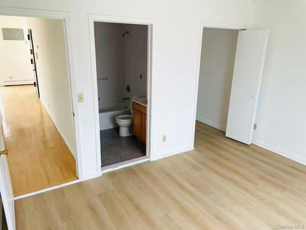 100-05 37th Avenue, Unit 4 Queens, NY 11368 - Photo 7 of 10 Unfurnished bedroom with light wood-style floors, a baseboard radiator, and ensuite bathroom