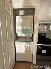 100-05 37th Avenue, Unit 4 Queens, NY 11368 - Photo 8 of 10 Laundry area featuring estacked washer and dryer and dark wood-type flooring
