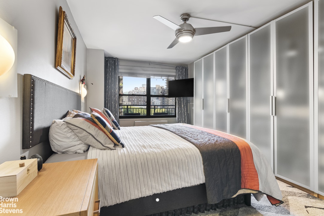 140 West End Avenue, Unit 11B Manhattan, NY 10023 - Photo 4 of 18 a bedroom with a bed and a chandelier