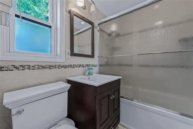 a bathroom with a sink toilet vanity and shower