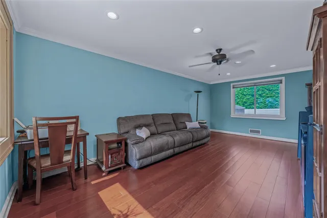 a living room with furniture and a wooden floor