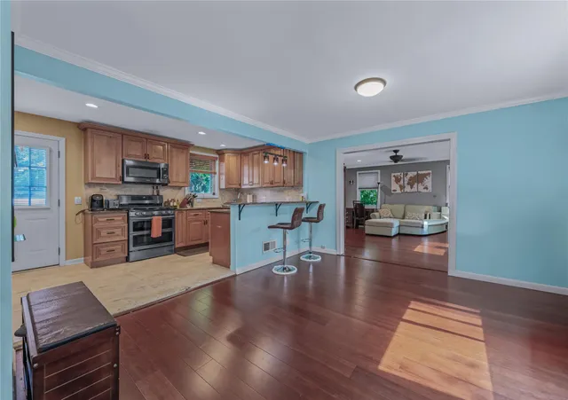 a kitchen with stainless steel appliances wooden floors and wooden cabinets