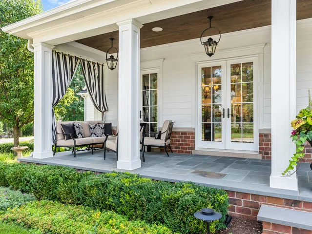 a room with lots of white furniture and windows