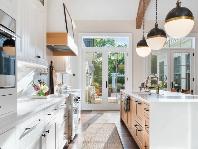 a bathroom with a double vanity sink a large mirror and a bathtub