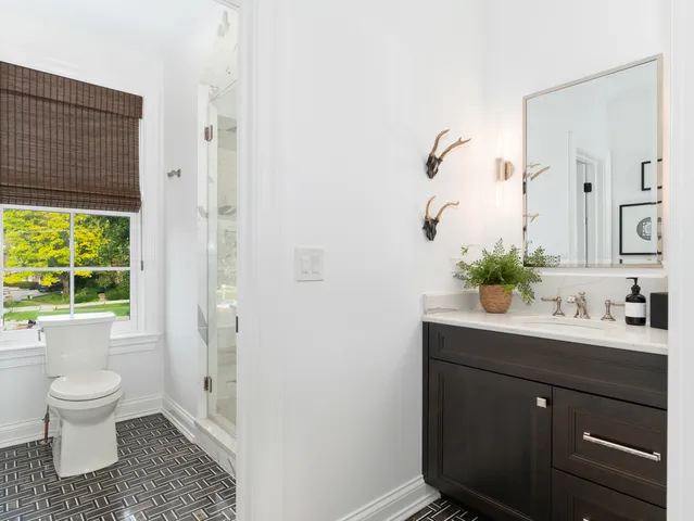 a spacious bathroom with a window sink and mirror