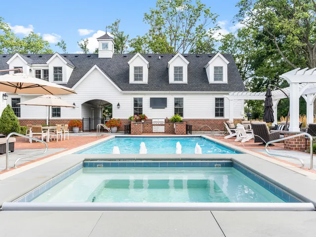 a front view of a house with swimming pool having outdoor seating
