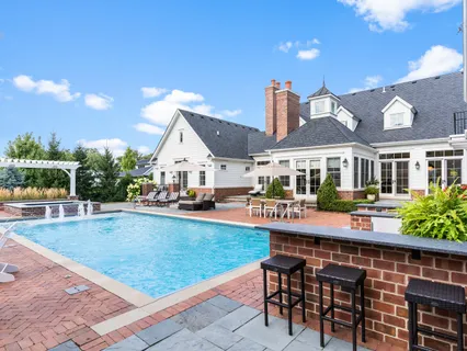 an aerial view of a house with swimming pool and patio