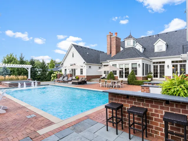 an aerial view of a house with swimming pool and patio