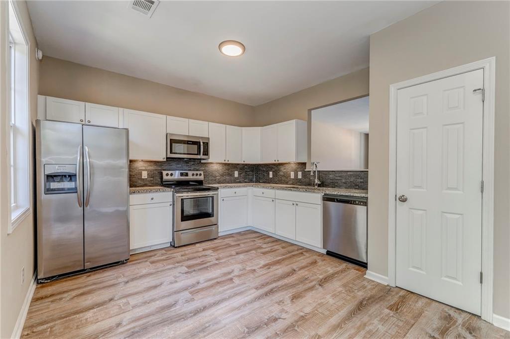 209 Enterprise Path Hiram, GA 30141 - Photo 11 of 31 a kitchen with granite countertop a refrigerator and a stove top oven