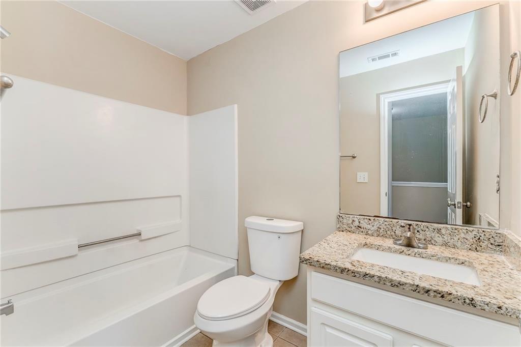 209 Enterprise Path Hiram, GA 30141 - Photo 19 of 31 a bathroom with a granite countertop toilet sink and mirror