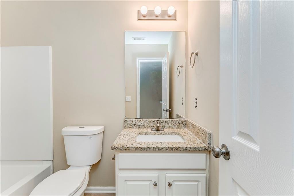 209 Enterprise Path Hiram, GA 30141 - Photo 20 of 31 a bathroom with a granite countertop sink mirror vanity and toilet