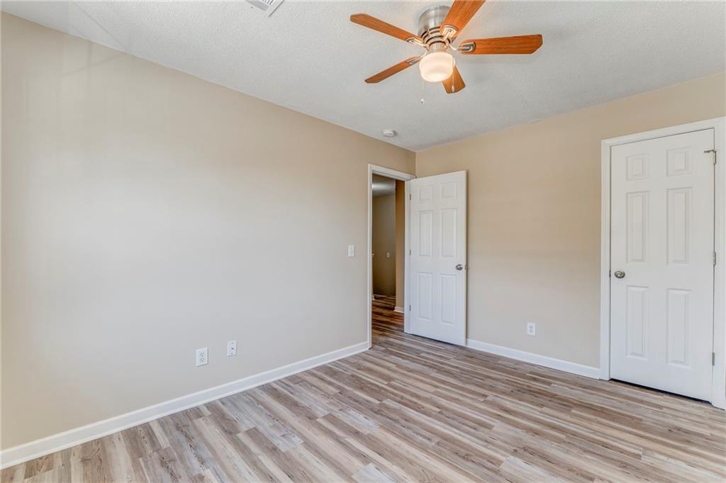 209 Enterprise Path Hiram, GA 30141 - Photo 21 of 31 an empty room with wooden floor ceiling fan and windows