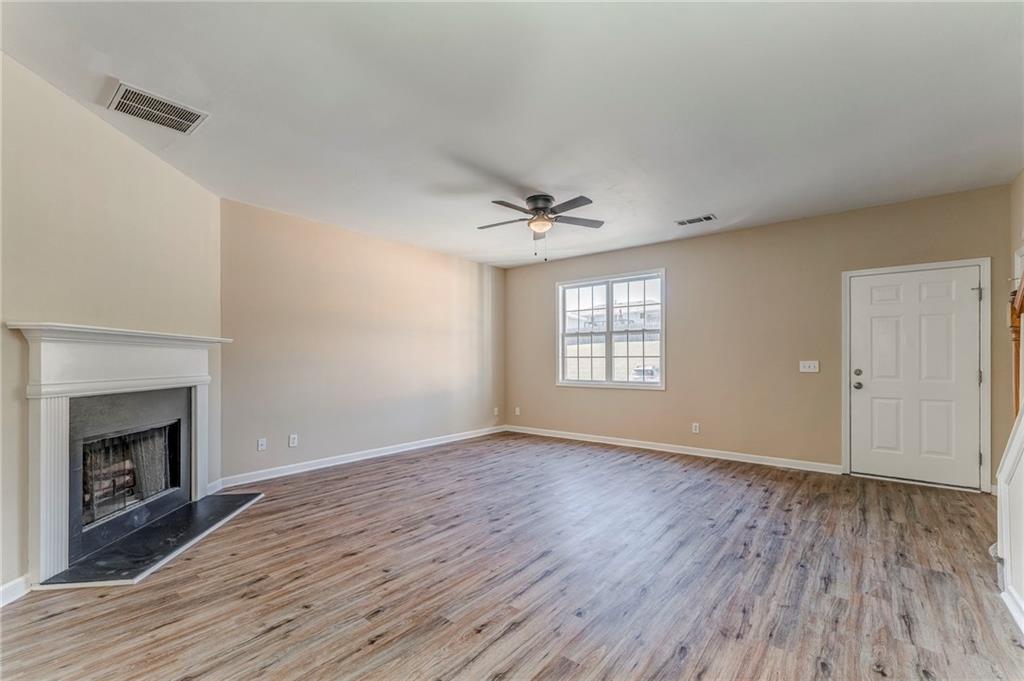 209 Enterprise Path Hiram, GA 30141 - Photo 5 of 31 an empty room with wooden floor fireplace and windows