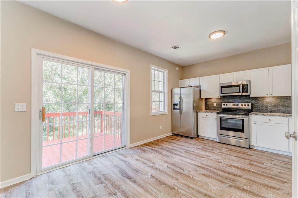 209 Enterprise Path Hiram, GA 30141 - Photo 7 of 31 a kitchen with granite countertop a stove a sink and a refrigerator