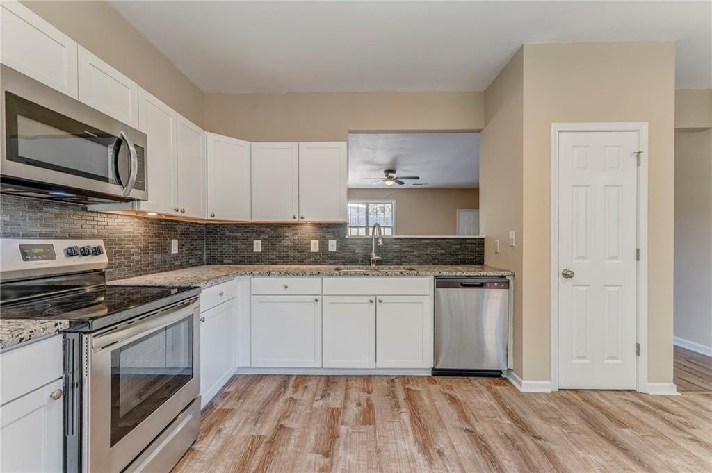 209 Enterprise Path Hiram, GA 30141 - Photo 8 of 31 a kitchen with stainless steel appliances granite countertop a stove a sink and a microwave