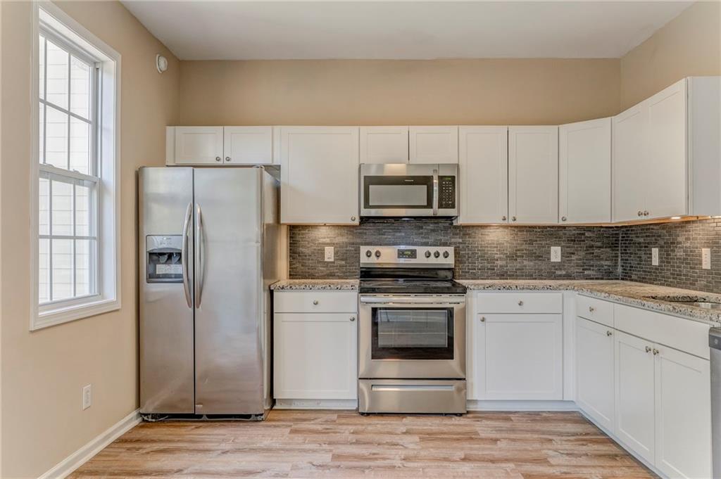 209 Enterprise Path Hiram, GA 30141 - Photo 9 of 31 a kitchen with cabinets stainless steel appliances and a window