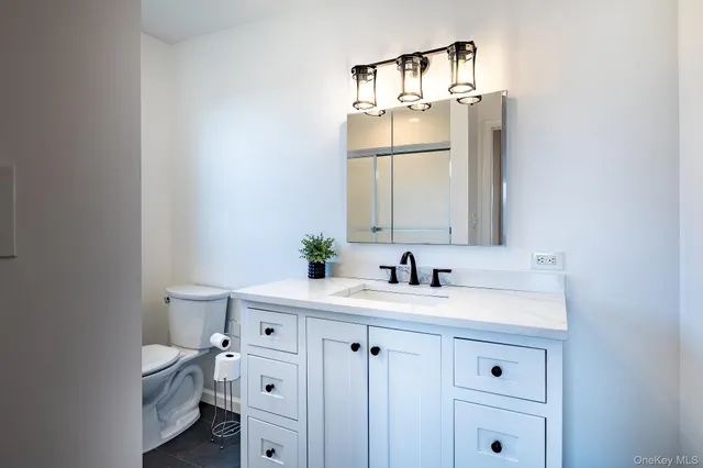 a bathroom with a sink vanity granite and a mirror