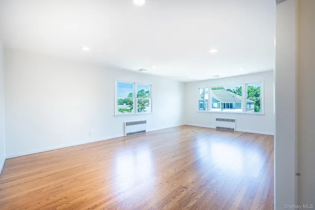 an empty room with window and wooden floor