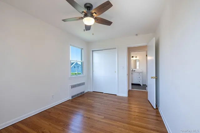 wooden floor in an empty room with a bathroom